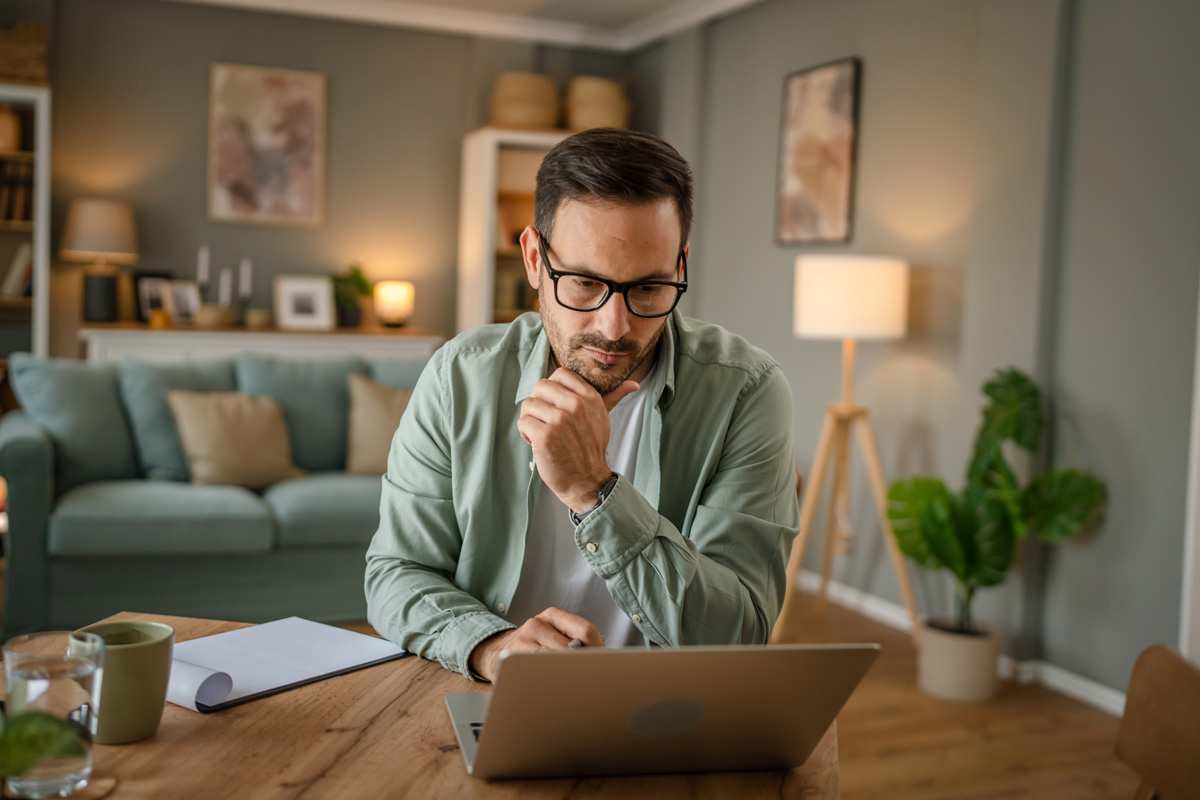 man on his house looking at a laptop